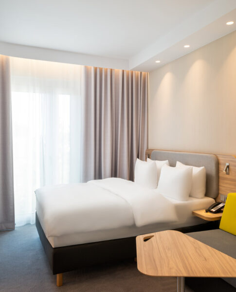 Ein Doppelzimmer mit Doppelbett und großem Fenster im Holiday Inn Express Rosenheim