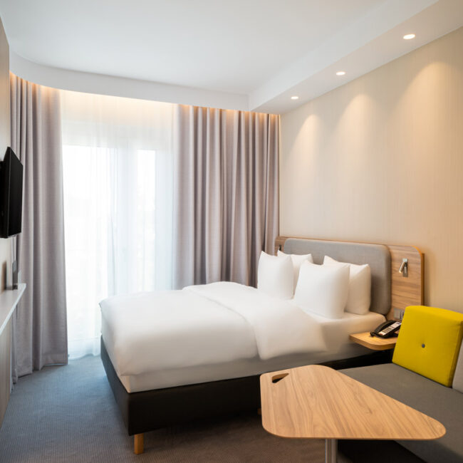 Ein Doppelzimmer mit Doppelbett und großem Fenster im Holiday Inn Express Rosenheim