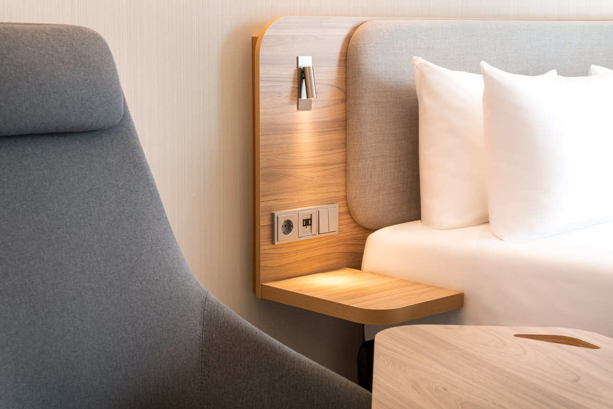 Der Nachttisch und die Lampen eines Zimmers im Holiday Inn Express Rosenheim