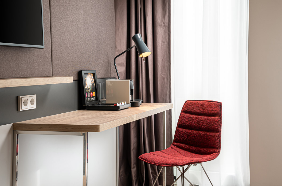 Der Arbeitsplatz mit Lampe in einem Zimmer im Holiday Inn Mannheim