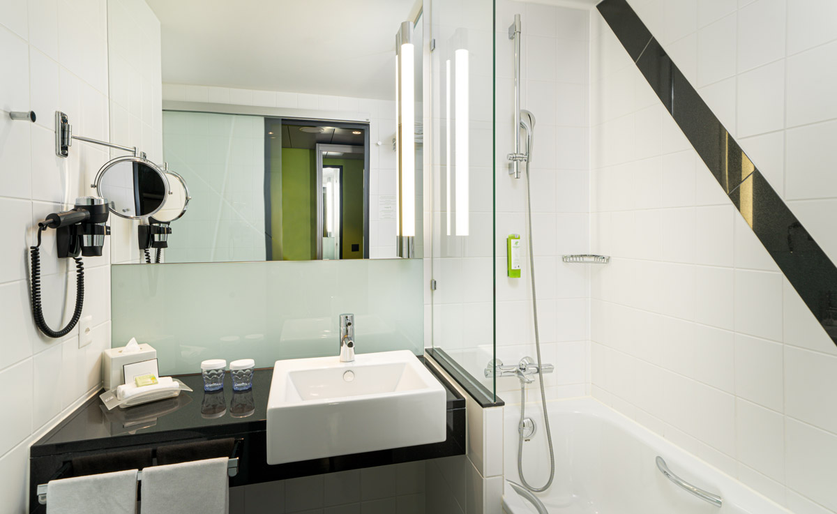 Das Badezimmer mit Badewanne eines Hotelzimmers im Holiday Inn Zürich Messe