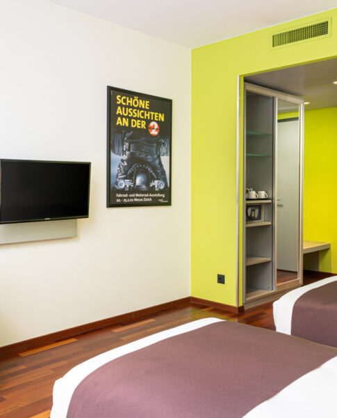 Ein Twin-Zimmer mit Einzelbetten und Fernseher im Holiday Inn Zürich Messe