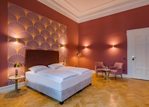 Das Doppelbett und die Sessel im Hotel Domicil