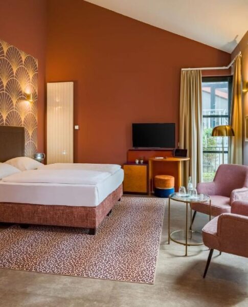 Ein Doppelzimmer mit Doppelbett und Sesseln im Hotel Domicil