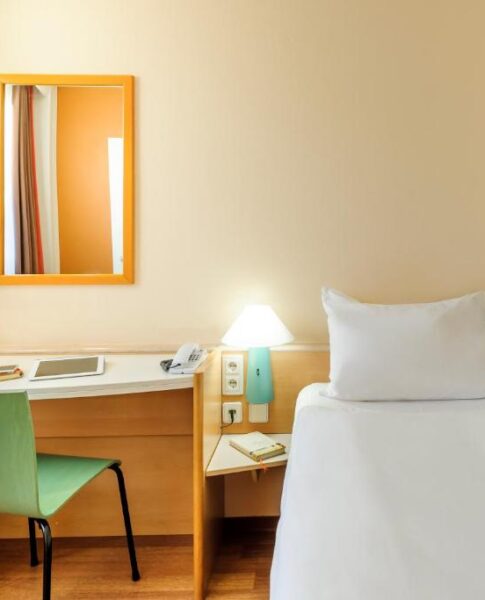 Die Betten und der Schreibtisch eines Twin-Zimmers im Ibis Augsburg Hauptbahnhof