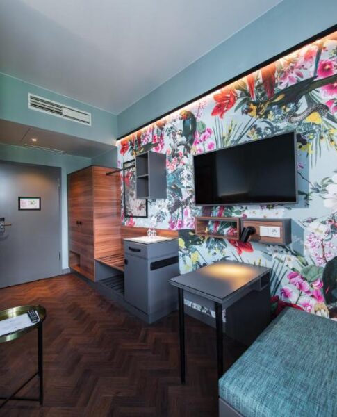 Der Fernseher und der Schreibtisch eines Zimmers im Maison Schiller