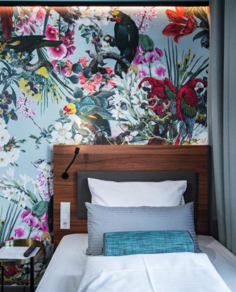 Das Bett eines Einzelzimmers mit Wandtapete im Maison Schiller