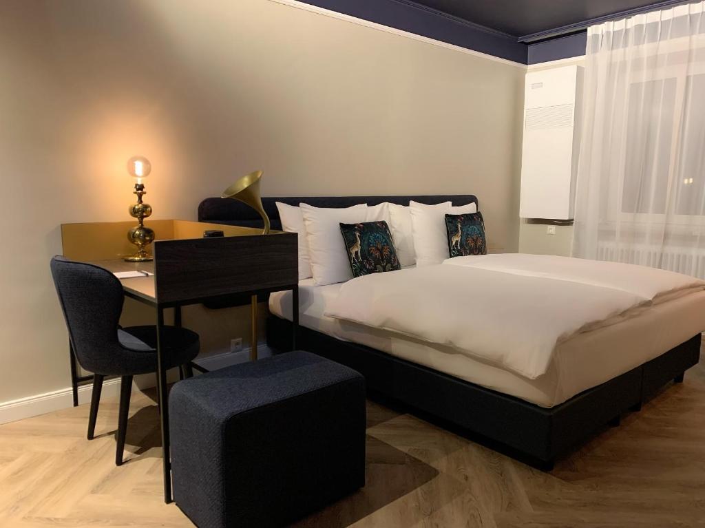 Das Doppelbett und der Schreibtisch mit Sessel im Maison Viktoria