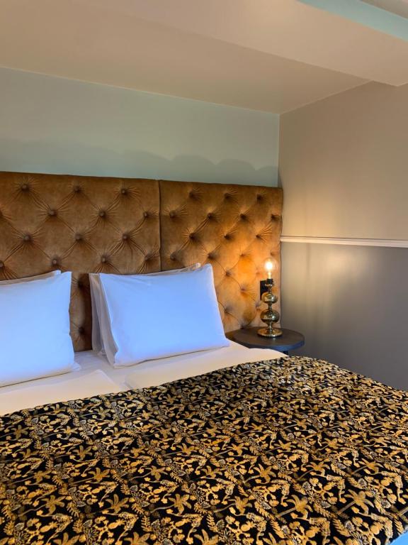 Das Doppelbett mit Kissen und Nachttisch im Maison Viktoria