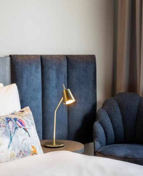 Der Sessel und das Bett eines Zimmers im Maison Viktoria