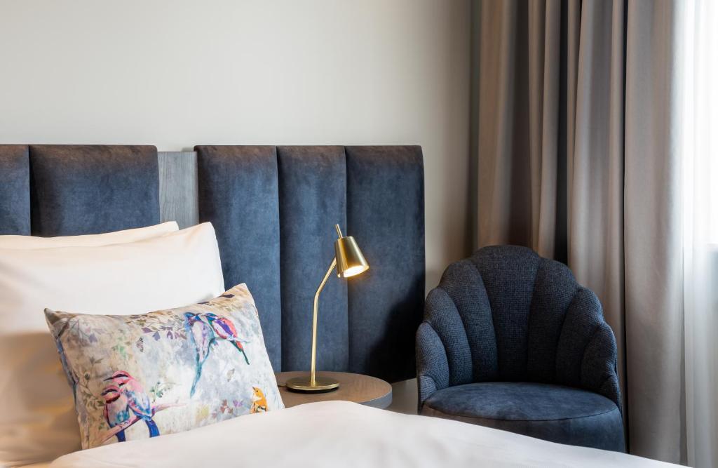 Der Sessel und das Bett eines Zimmers im Maison Viktoria