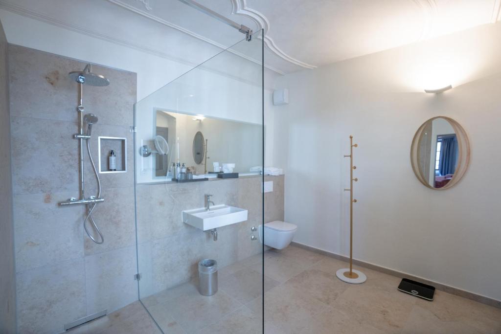 Das Badezimmer und der Spiegel eines Zimmers im Maxim Suites