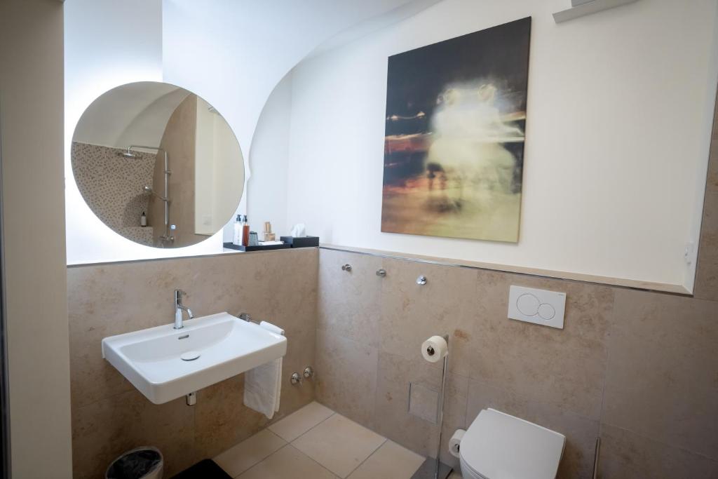 Das Badezimmer mit Spiegel und Wachbecken im Maxim Suites