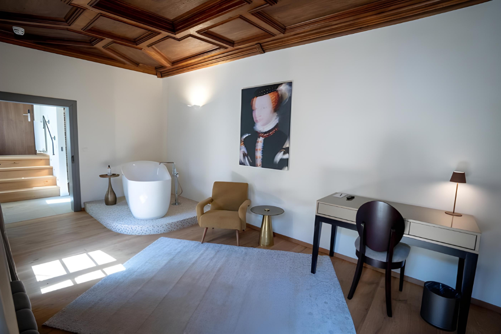 Der Schreibtisch und die Badewanne eines Zimmers im Maxim Suites