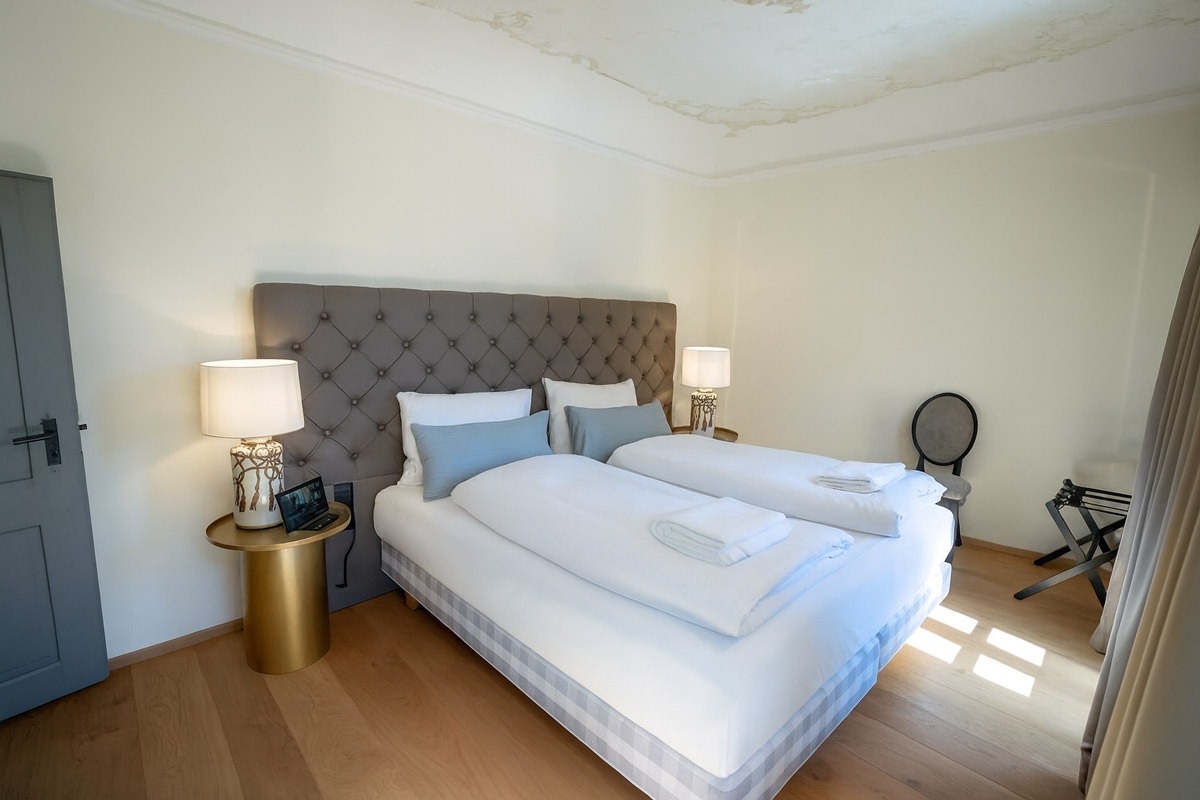 Ein Doppelzimmer mit Bett und Stuhl im Maxim Suites