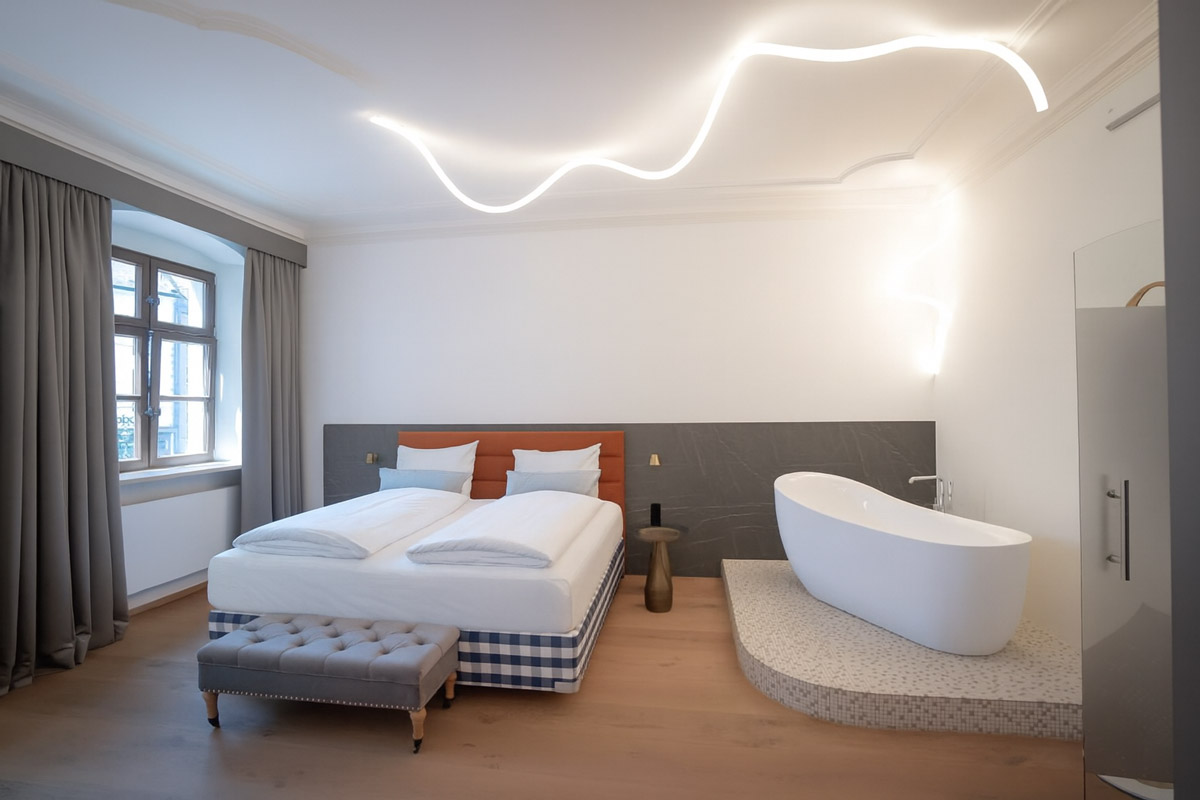 Ein Doppelzimmer mit Badewanne im Maxim Suites