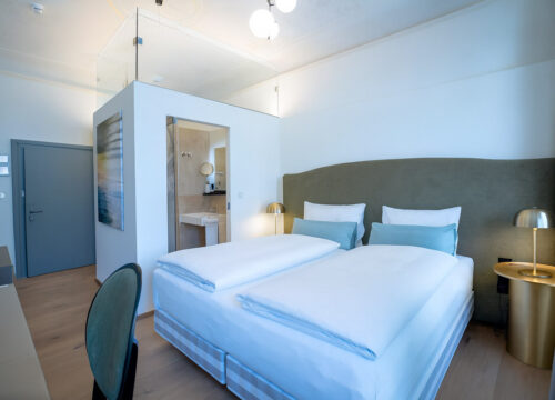 Ein Doppelzimmer mit Nachttischen und Lampen im Maxim Suites