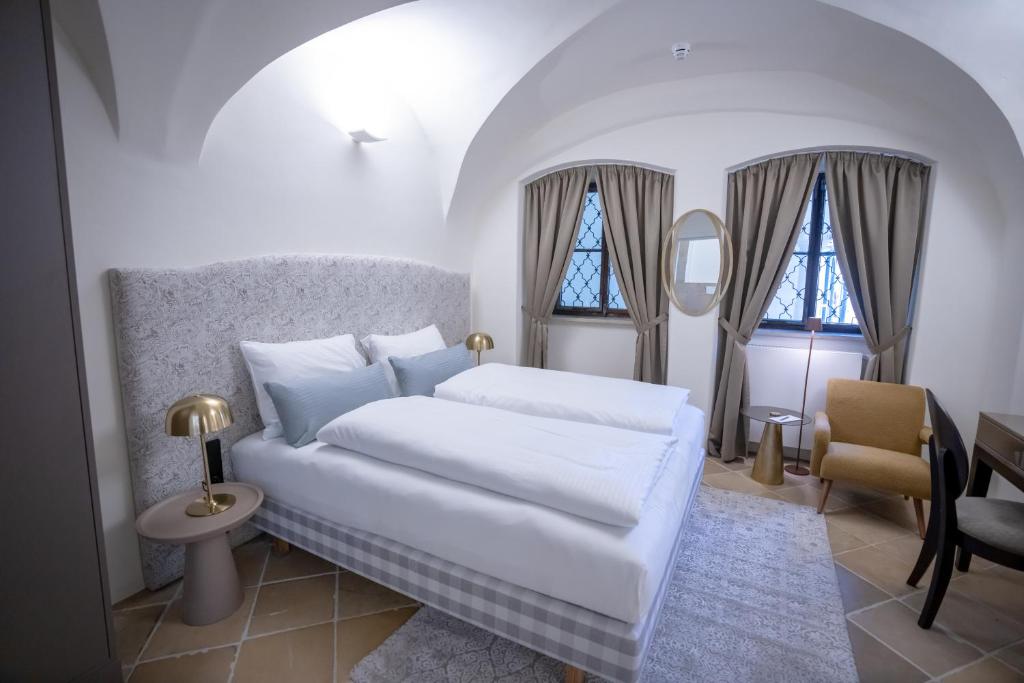 Ein Doppelzimmer mit Doppelbett und Sitzgelegenheit im Maxim Suites