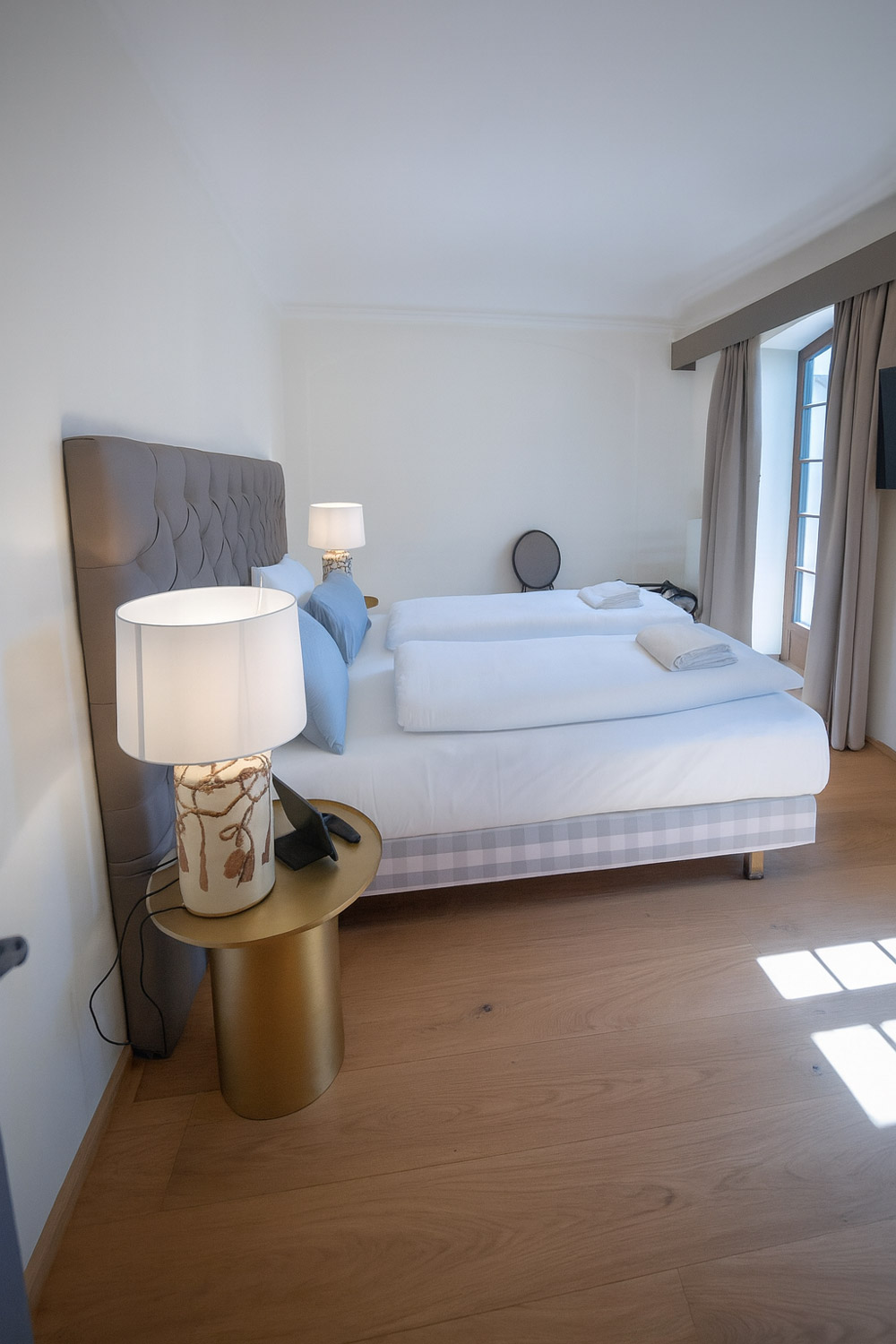 Ein Doppelzimmer mit Bett und Nachttisch im Maxim Suites