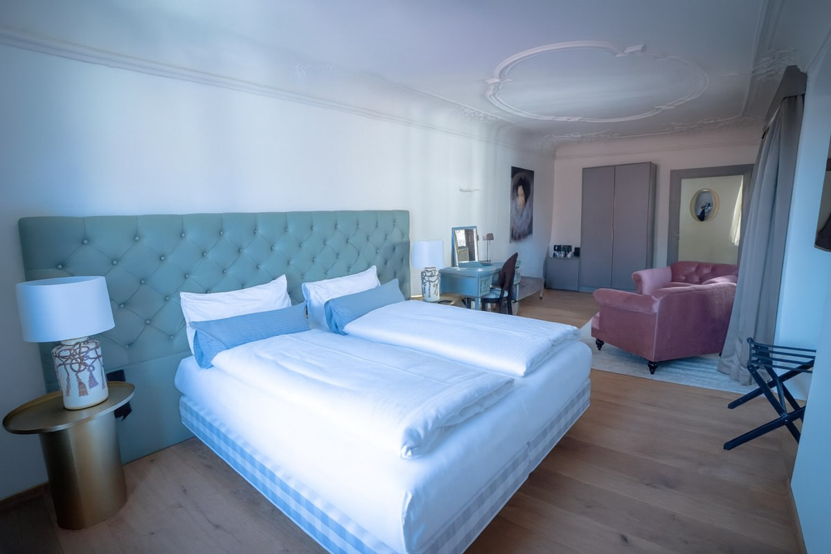 Ein Doppelzimmer mit Bett und Sofa im Maxim Suites