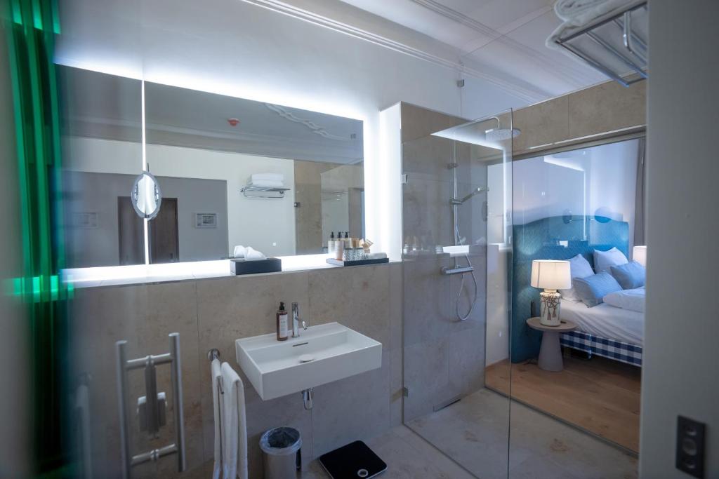 Das Badezimmer mit Dusche und Waschbecken im Maxim Suites