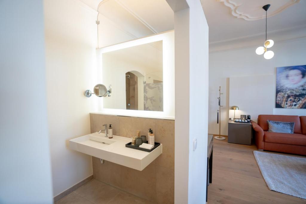 Das Waschbecken und das Sofa eines Zimmers im Maxim Suites