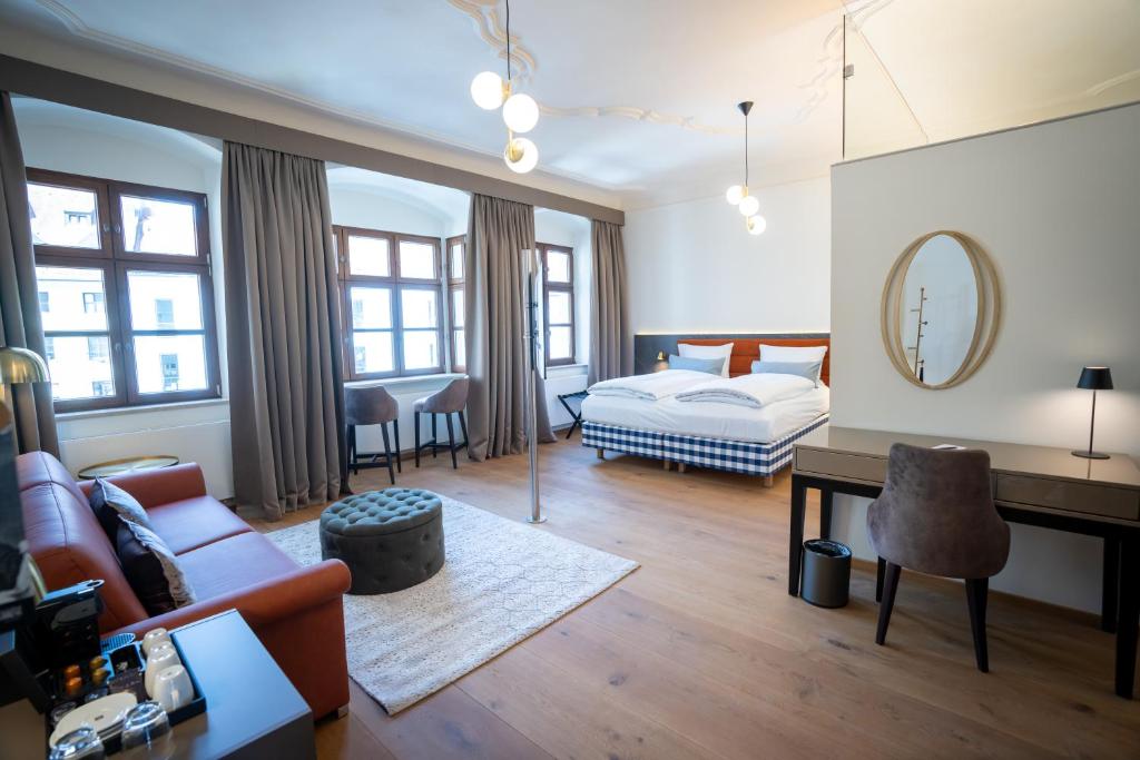 Der Schreibtisch und der Wohnbereich eines Zimmers im Maxim Suites