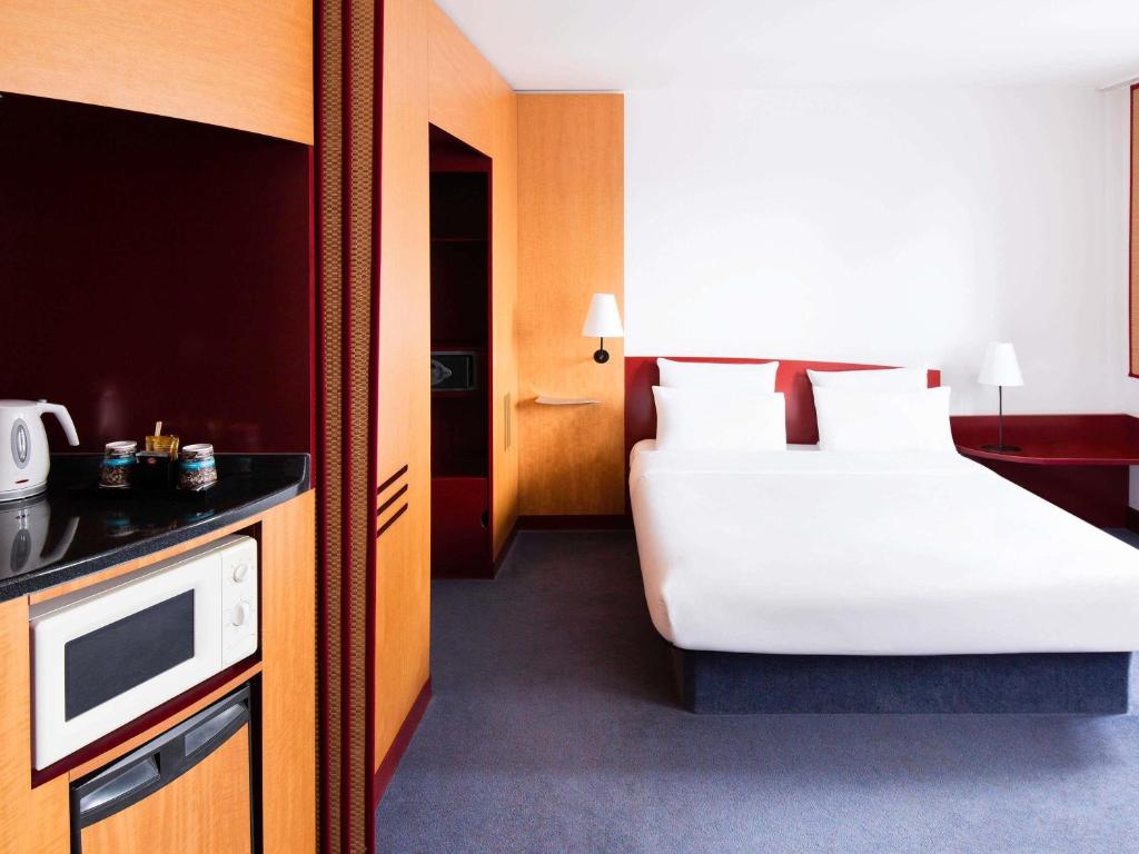 Ein Doppelzimmer mit Doppelbett und Schrank im Novotel Suites Hannover City