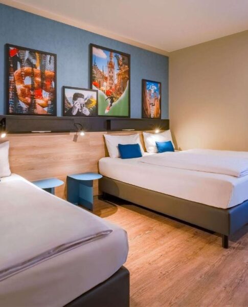Das Dreibettzimmer mit Wanddekoration im Ramada Encore by Wyndham Munich Messe