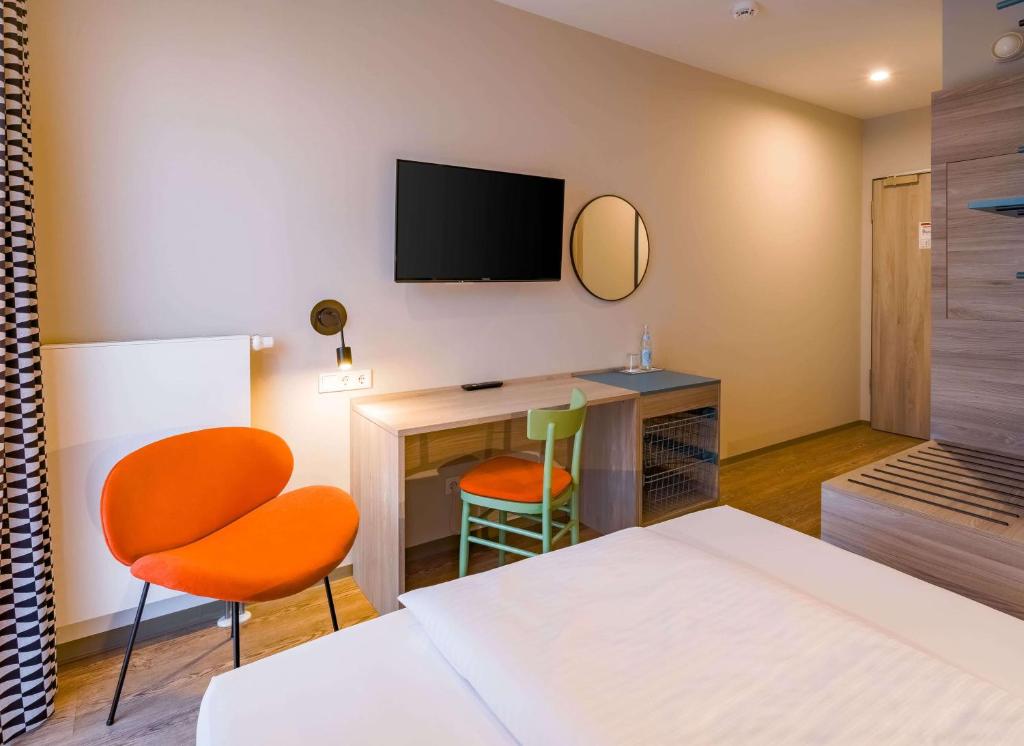 Ein Einzelzimmer mit Schreibtisch im Ramada Encore by Wyndham Munich Messe