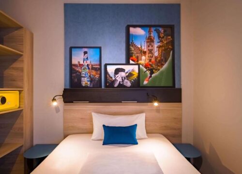 Ein Einzelzimmer mit Wanddekoration im Ramada Encore by Wyndham Munich Messe