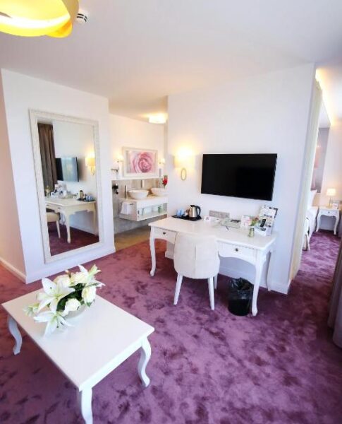 Der Arbeitsbereich eines Zimmers mit Fernseher im rugs Hotel am Schlosspark Lichtenwalde