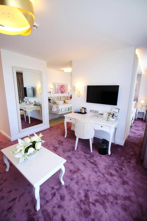 Der Arbeitsbereich eines Zimmers mit Fernseher im rugs Hotel am Schlosspark Lichtenwalde