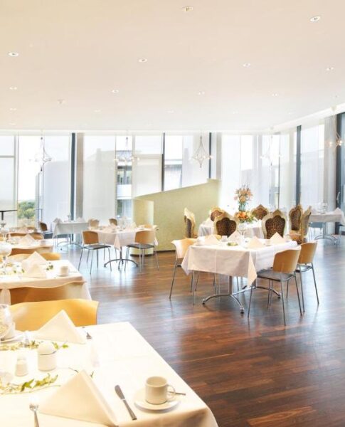 Tische und Stühle im Speisesaal im rugs Hotel am Schlosspark Lichtenwalde