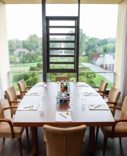 Die Tagungssuite mit Tisch und Stühlen im rugs Hotel am Schlosspark Lichtenwalde