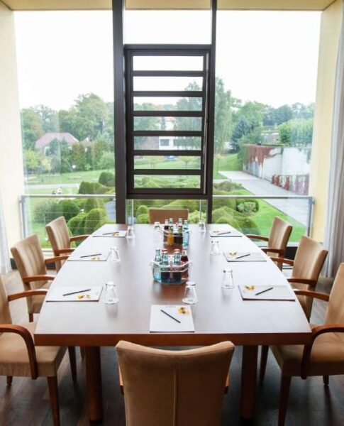 Die Tagungssuite mit Tisch und Stühlen im rugs Hotel am Schlosspark Lichtenwalde