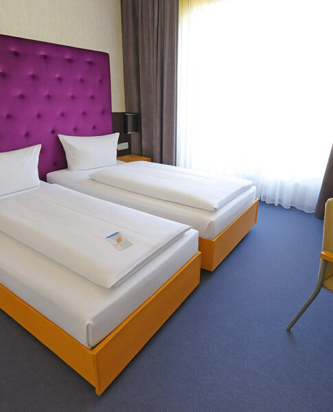 Die Einzelbetten eines Twin-Zimmers im rugs Hotel am Schlosspark Lichtenwalde