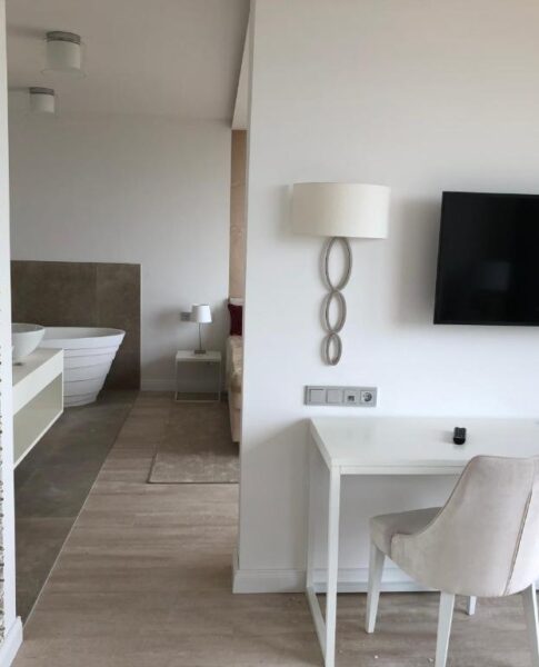 Der Arbeitsbereich mit Schreibtisch und Fernseher eines Zimmers im rugs Hotel am Schlosspark Lichtenwalde