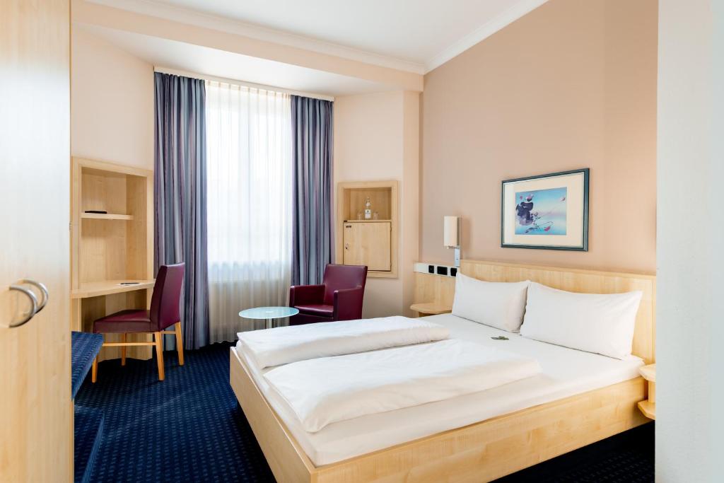 Ein Doppelzimmer mit Doppelbett und Schreibtisch im rugs Hotel Augsburg
