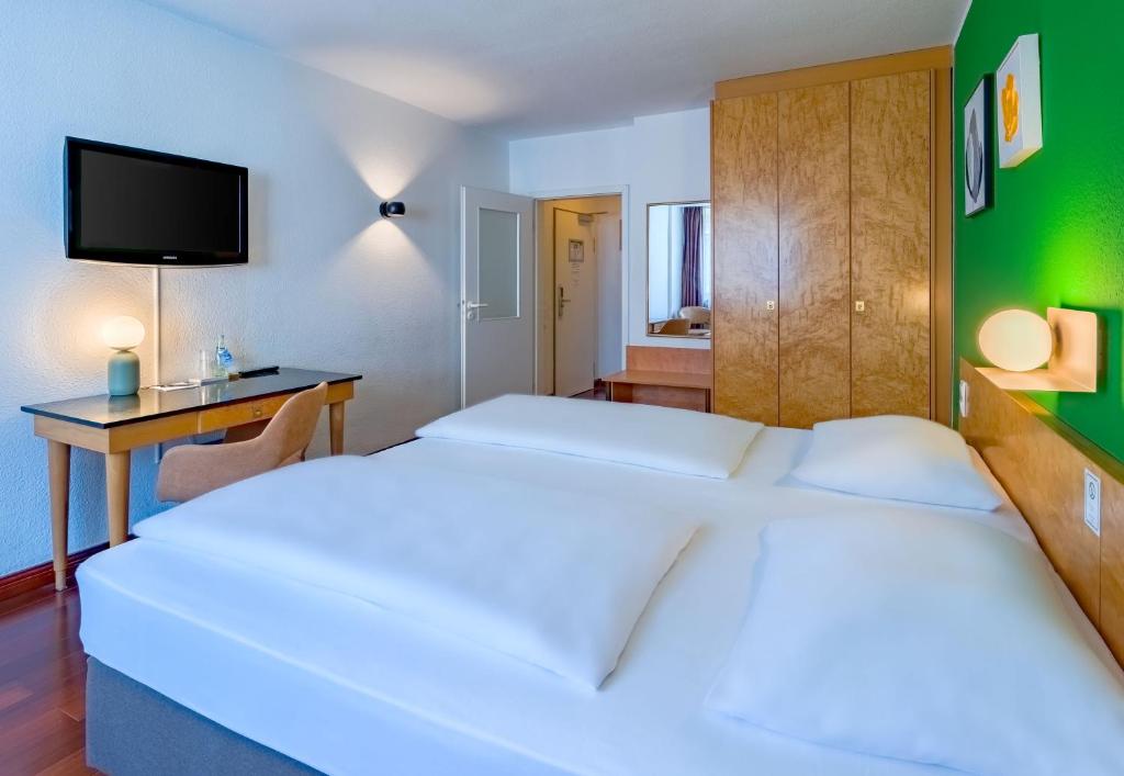 Ein Doppelzimmer mit Fernseher im rugs Hotel Düsseldorf