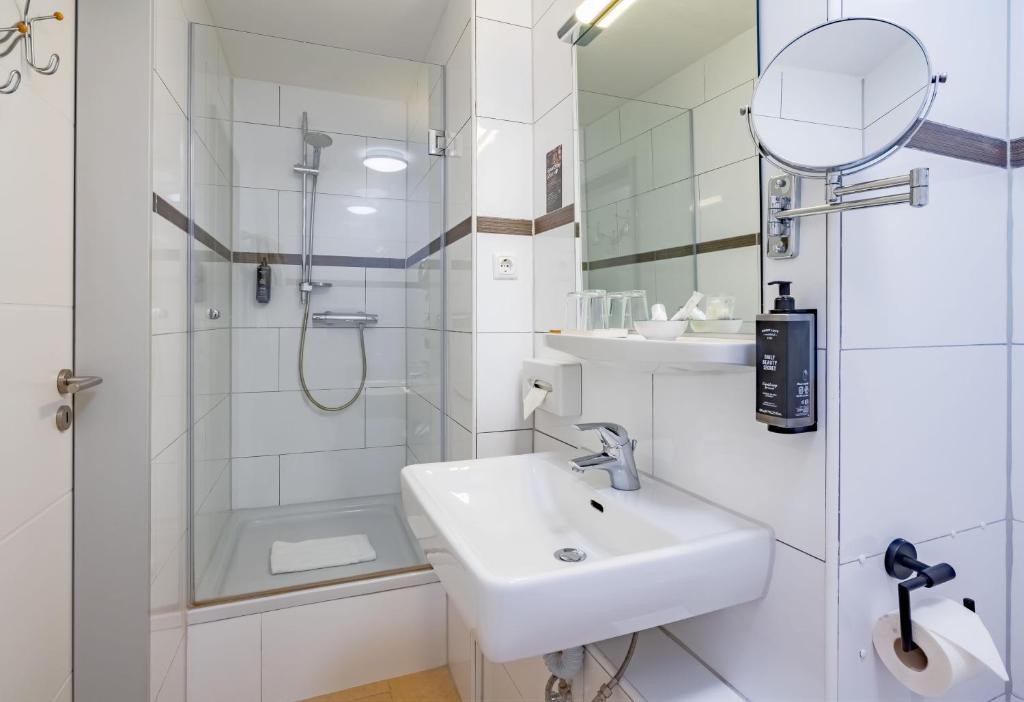 Das Badezimmer mit Dusche und Waschbecken im rugs Hotel Düsseldorf