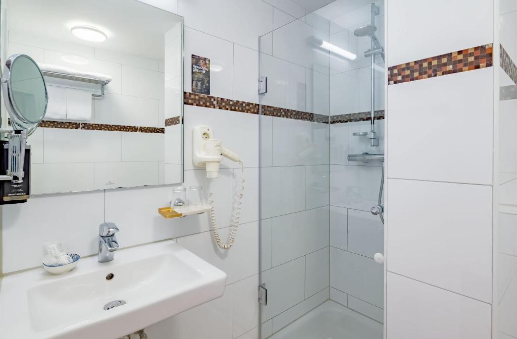 Das Badezimmer mit Dusche und Waschbecken im rugs Hotel Düsseldorf