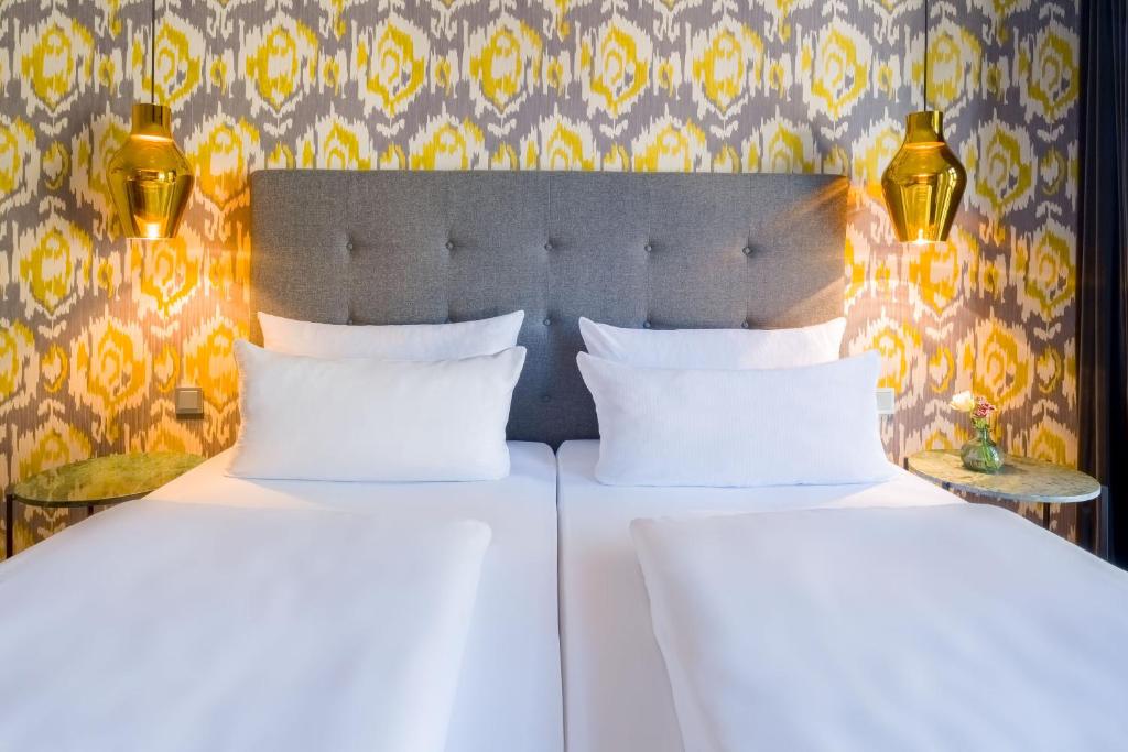 Das Doppelbett und die Lampen eines Zimmers im rugs Hotel Köln