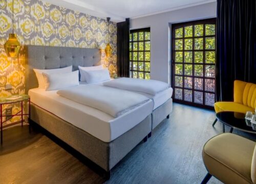 Das Doppelbett und die Fenster eines Doppelzimmers im rugs Hotel Köln