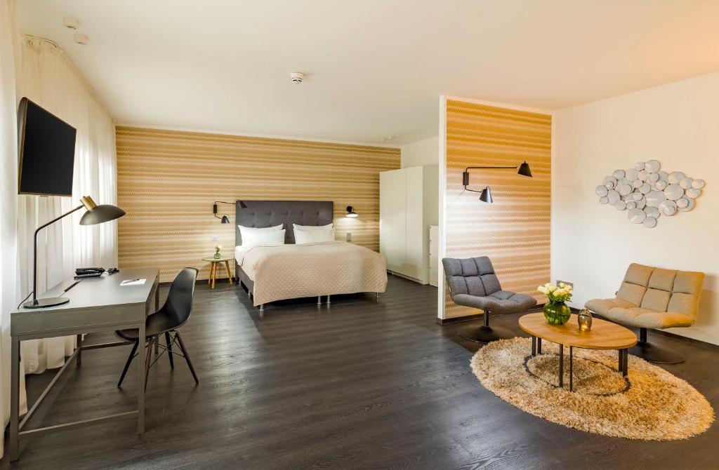 Der Arbeitsplatz und Sitzgelegenheiten eines Zimmers im rugs Hotel Köln