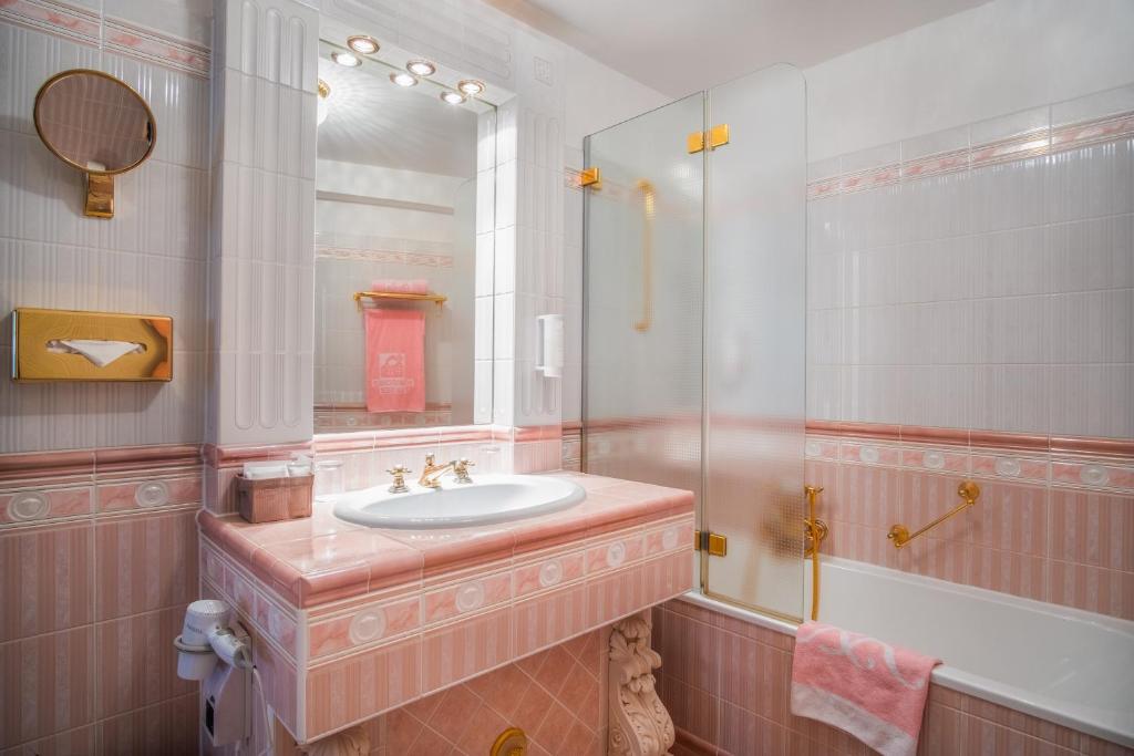 Eine Badewanne mit Dusche im Schlosshotel Römischer Kaiser