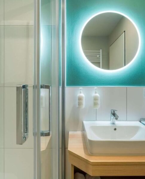 Ein Waschbecken und ein moderner Spiegel im Badezimmer