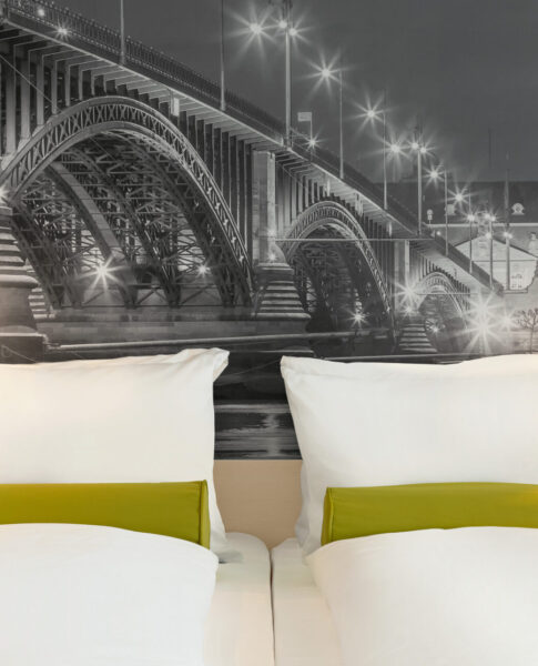 Das Doppelbett und die Nachttische eines Zimmers im Super8 by Wyndham Mainz Zollhafen