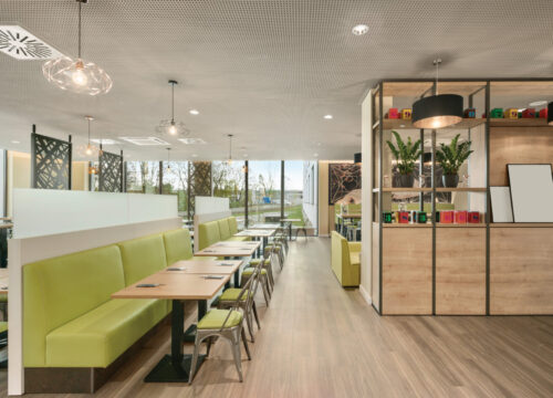 Der Frühstücksraum mit Tischen und Stühlen im Super8 by Wyndham Munich City North