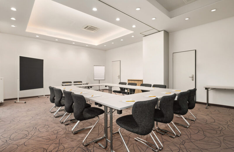 Ein Tagungsraum mit Tischen und Stühlen im Super8 by Wyndham Munich City North